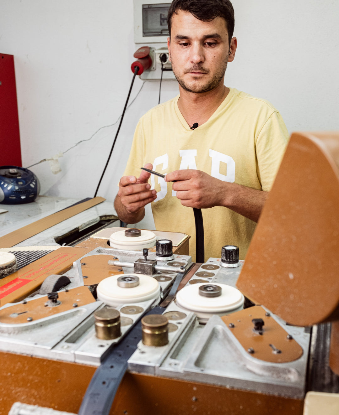A leather craftsman handcrafting a genuine leather KAZARTT belt in a family workshop in Spain.